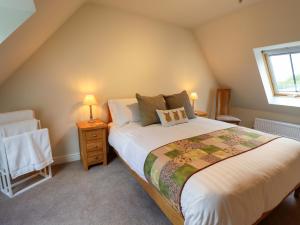 a bedroom with a large bed and a window at Bobblehat Barn in Alford