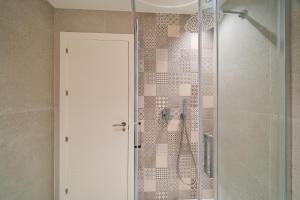 a shower with a glass door in a bathroom at Hostal Sol y Miel in Benalmádena