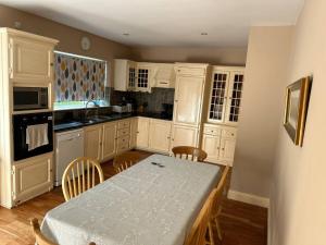 a kitchen with white cabinets and a table with chairs at The Sanctuary in Killavullen +8 photos