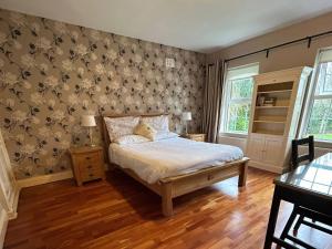 a bedroom with a bed and a wall with wallpaper at The Sanctuary in Killavullen