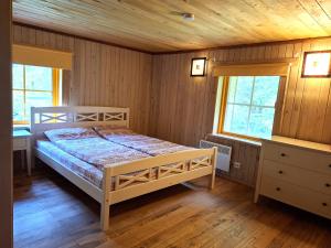 a bedroom with a bed and two windows at Sika Holiday Houses in Hellamaa
