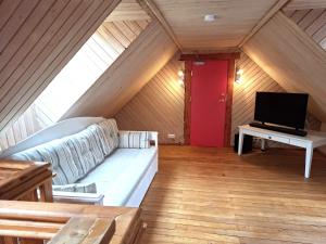 a living room with a couch and a flat screen tv at Sika Holiday Houses in Hellamaa
