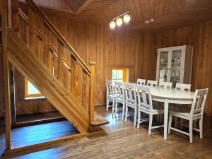 a dining room with a white table and chairs at Sika Holiday Houses in Hellamaa