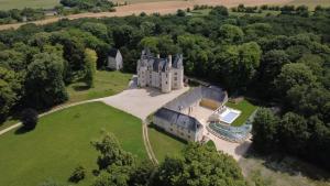 an aerial view of a castle in the trees at Gîte du Château des Brétignolles - Patrimoine, Piscine & Nature - Près de Chinon in Anché
