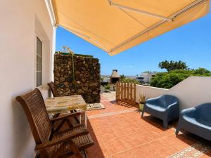 a patio with chairs and a table and an umbrella at Casa VEROLES in Tías