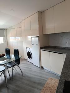 a kitchen with a table and a washing machine in it at Casa de Férias Terra e Mar in Póvoa de Varzim