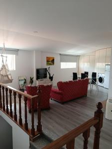 a living room with two red couches and a television at Casa de Férias Terra e Mar in Póvoa de Varzim