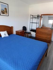 a bedroom with a blue bed and a dresser at Casa de Férias Terra e Mar in Póvoa de Varzim