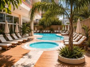 a swimming pool with lounge chairs and a palm tree at Bella Rose Apart Hotel, Alanya in Alanya