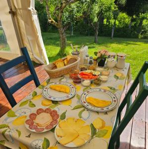 a table with plates of food and a basket of bread at Green Eden in Gornji Zvečaj