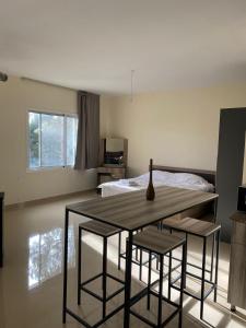 a room with a table and two chairs and a bed at Chalet 102 - Zresidence - Faitroun in Al ‘Aqabah