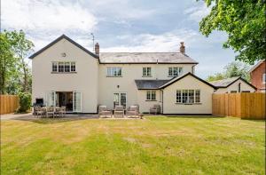 an exterior view of a house with a yard at Dalforth Thaxted Barn Collection in London Stansted Airport