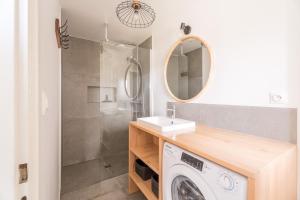 a bathroom with a washing machine and a sink at Chez Mémé in Engenthal