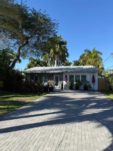 a white house with palm trees in front of it at Flip Flops 1 mile beach stadium close in Hollywood