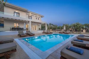 a swimming pool with lounge chairs and a house at Villa V - Infinity Holiday Villas, For Large Groups With Private Pool, by ZanteWize in Kalamaki