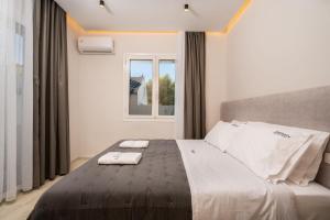 a bedroom with a bed with two towels on it at Villa V - Infinity Holiday Villas, For Large Groups With Private Pool, by ZanteWize in Kalamaki