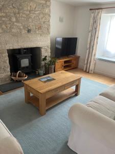 a living room with a coffee table and a fireplace at Gorse cottage in Newton Abbot