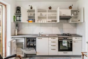 a kitchen with white cabinets and a sink at Apartma Jager in Bovec +20 photos