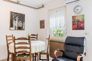 a room with a table and a chair and a clock at Apartma Jager in Bovec