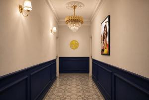 a hallway with a chandelier on the wall and a hallway sidx sidx sidx at Hotel Granton By Carlton Suites in Hyderabad