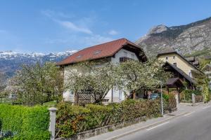 a house on the side of a street with mountains at Apartma Jager in Bovec