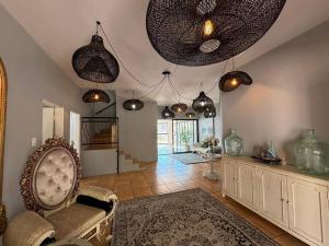 a living room with a chair and pendant lights at Khenjadji at Fish Eagle Bay in Bela-Bela