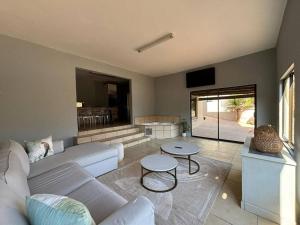 a living room with a white couch and a table at Khenjadji at Fish Eagle Bay in Bela-Bela