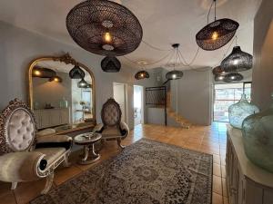 a living room with chairs and a mirror at Khenjadji at Fish Eagle Bay in Bela-Bela +46 photos