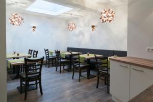 a dining room with tables and chairs and chandeliers at Anitas Altstadtpension in Kelheim