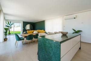 a kitchen and dining room with a table and chairs at Casa Caracol, with a panoramic ocean view in Lourinhã