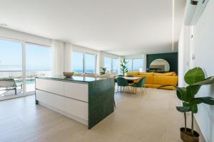 a kitchen and living room with a view of the ocean at Casa Caracol, with a panoramic ocean view in Lourinhã