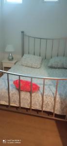a metal bed frame with a red pillow on it at Les Ouilerres in Mervent