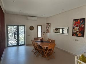 a dining room with a table and chairs and a window at Dar Zaytouna in Oulad Akkou +23 photos