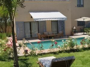 a house with a swimming pool in the yard at Dar Zaytouna in Oulad Akkou