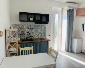 a kitchen with a white table and a kitchen with a window at Ca' Salino in Villa Inferno