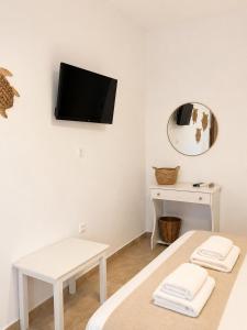 a room with two beds and a tv on the wall at Pension Anastasia in Ammouliani