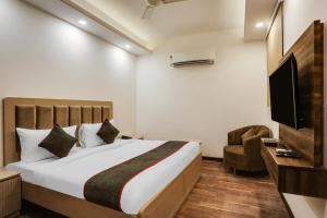 a bedroom with a bed and a flat screen tv at Super Townhouse MA-32 in Gurgaon +24 photos