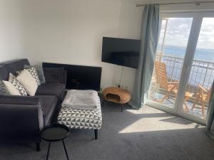 a living room with a couch and a view of the ocean at Harbour Point Apartment in Saltcoats