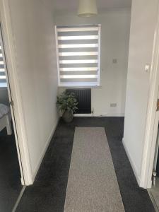 an empty room with a window and a potted plant at Harbour Point Apartment in Saltcoats +1 photo