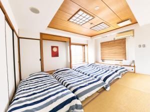 three beds in a room with a skylight at The Little Kamakura Hotel 鎌倉駅徒歩2分 in Kamakura