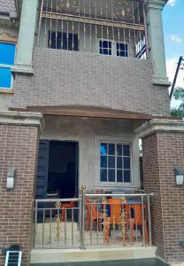 a building with tables and chairs on a balcony at WF&DGS Care LODGE in Owerri