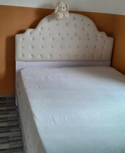 a white bed with a stuffed animal on top of it at WF&DGS Care LODGE in Owerri