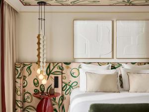 a bedroom with a bed and a wall with floral wallpaper at Grand Hôtel Roi René Aix - MGallery Collection in Aix-en-Provence +133 photos