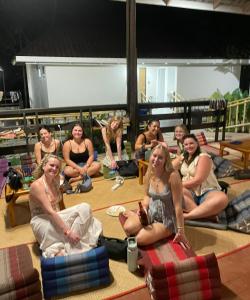 a group of people sitting on the floor at Lazy Garden Hostel in Phra Ae beach