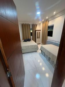 a hotel room with two beds and a bathroom at Apartamento Frente Mar in Jacumã +23 photos