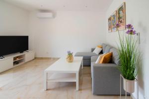 a living room with a couch and a table at Vacation apartments Mario with salt water pool in Turjaci