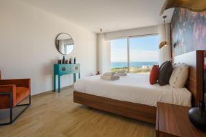 a bedroom with a large bed with a large window at Casa Caracol, with a panoramic ocean view in Lourinhã
