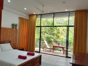 a bedroom with a bed and a view of a balcony at Green cottage Ella in Ella
