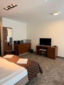a hotel room with two beds and a flat screen tv at Pokoje Hotel Diva 200 metrów do plaży in Kołobrzeg