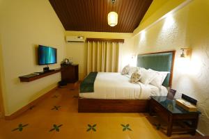 a bedroom with a bed with a dog sitting on it at Anaasa Resorts in Tiruvannāmalai